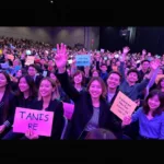 Fans cheering and holding up signs at the TFBOYS 2018 fan meeting