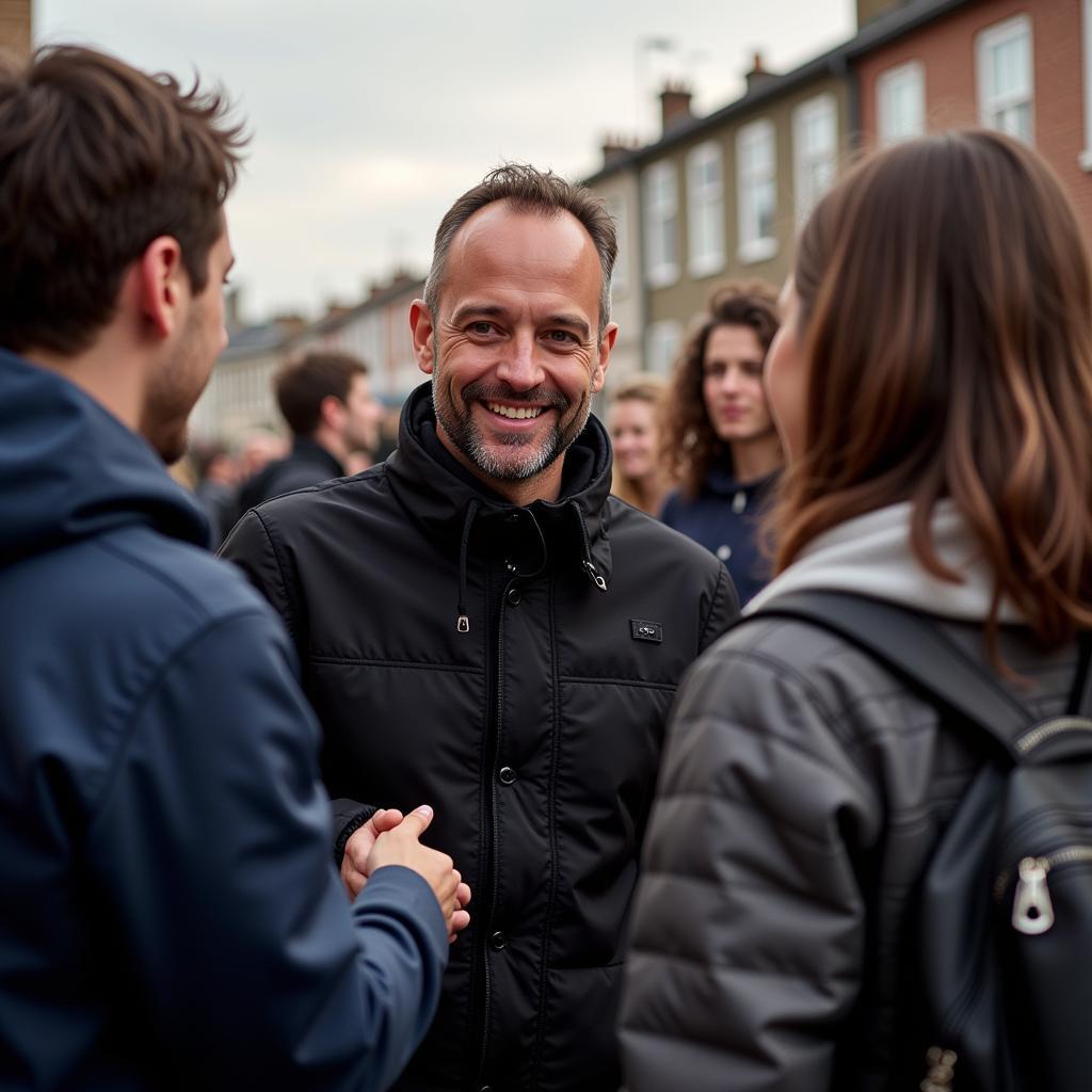 Den Vau meeting with fans at a meet-and-greet event, taking photos and signing autographs.