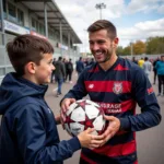 Fan getting an autograph from a football player with a ballpen