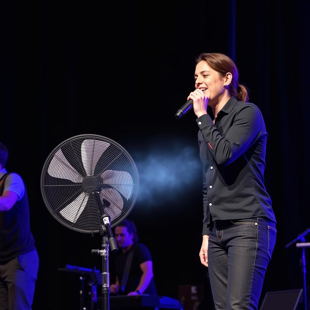 Singer performing live on stage with a Giga 1050 fan for cooling