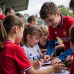 Youth academy players interacting with young fans.